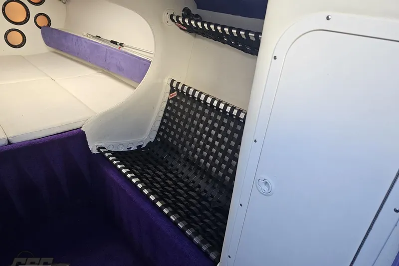 Slide: The Image of Interior of 2001 Baja 36 Outlaw boat with purple and white seating. - 65