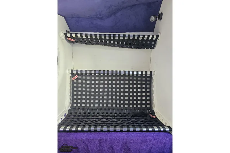 Slide: The Image of Interior of 2001 Baja 36 Outlaw boat with black netted storage shelves. - 66