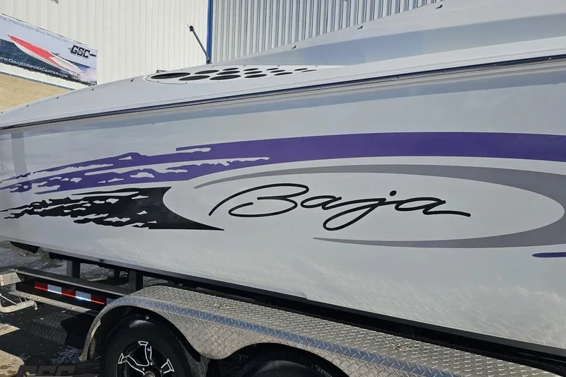 Slide: The Image of 2001 Baja 36 Outlaw boat with purple and black graphics on trailer. - 7