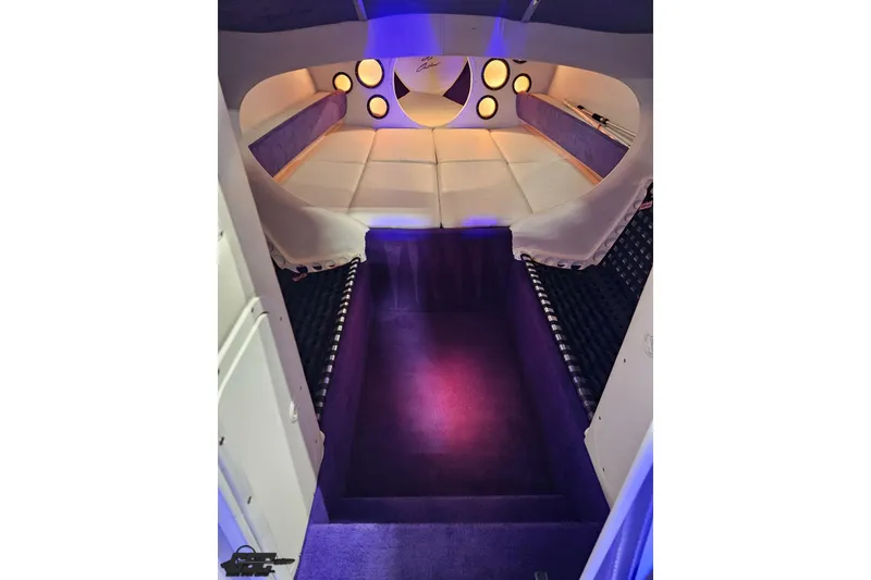 Slide: The Image of Interior of 2001 Baja 36 Outlaw boat with purple and white seating, ambient lighting. - 70