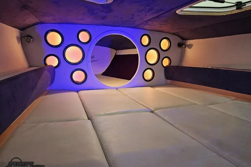 Slide: The Image of Interior of a 2001 Baja 36 Outlaw boat with illuminated speakers and cushioned seating. - 72