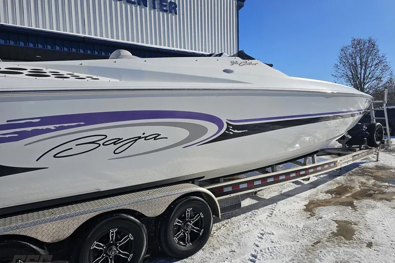 Slide: The Image of 2001 Baja 36 Outlaw boat on trailer, featuring sleek design and purple accents. - 8
