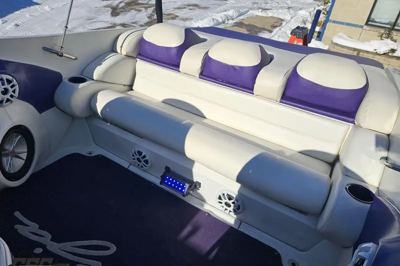 Slide: The Image of 2001 Baja 36 Outlaw boat interior with white and purple seating, speakers, and cup holders. - 80