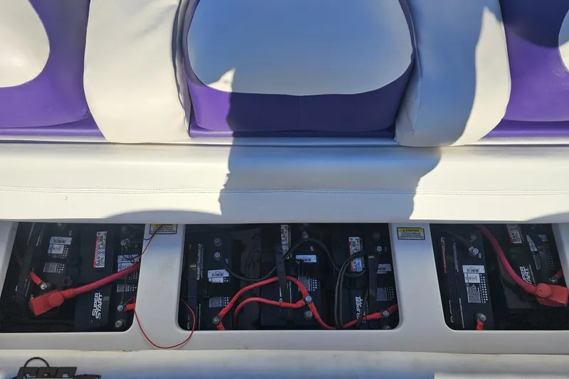 Slide: The Image of 2001 Baja 36 Outlaw boat battery compartment with multiple batteries and wiring. - 82