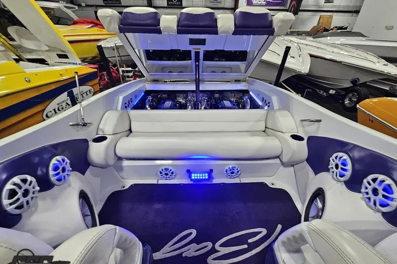 Slide: The Image of 2001 Baja 36 Outlaw boat interior with open engine compartment, white and purple seating, and speakers. - 84