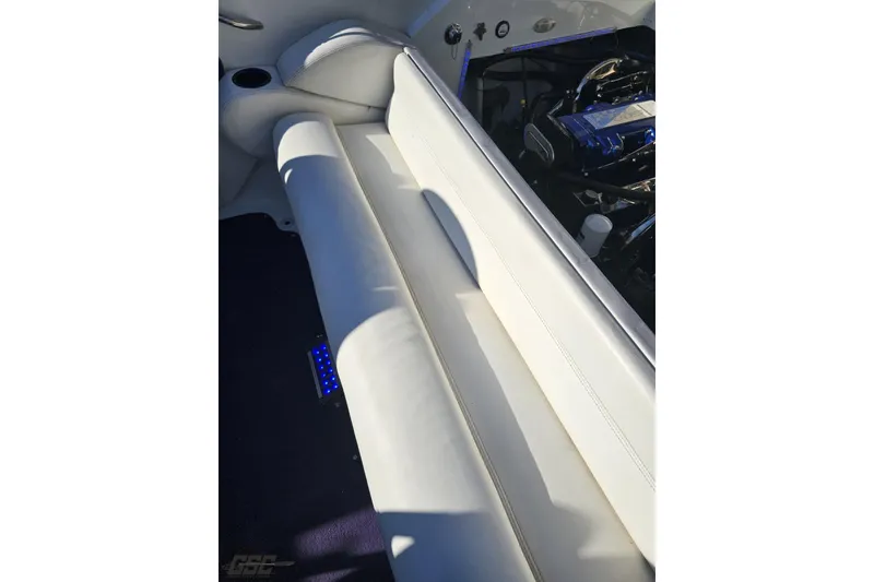 Slide: The Image of Interior of 2001 Baja 36 Outlaw boat with white seating and engine view. - 89