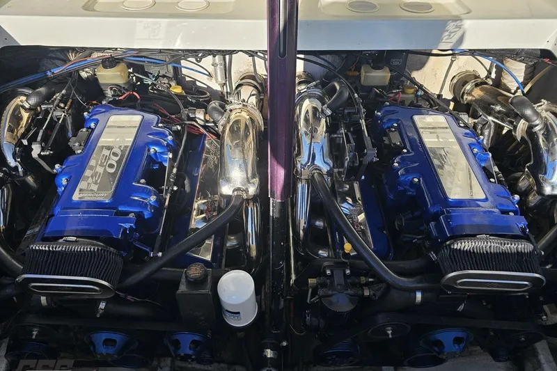Slide: The Image of Twin engines of a 2001 Baja 36 Outlaw boat, featuring blue and chrome details. - 90
