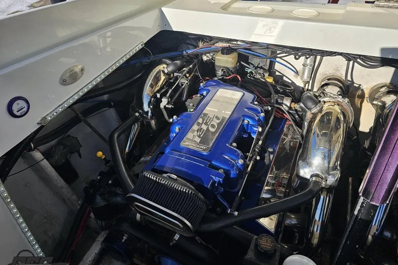 Slide: The Image of Engine of a 2001 Baja 36 Outlaw boat, featuring a blue cover and chrome components. - 93