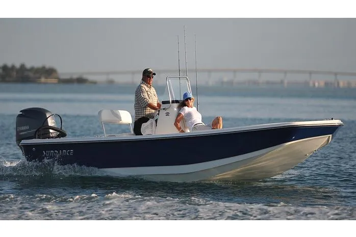 Slide: The Image of Manufacturer Provided Image: 2025 Sundance DX20 boat cruising on calm water with two passengers. - 2