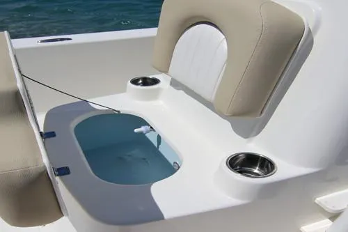 Slide: The Image of Manufacturer Provided Image: 2025 Sundance DX20 boat with beige seating, on calm water under a clear sky. - 8