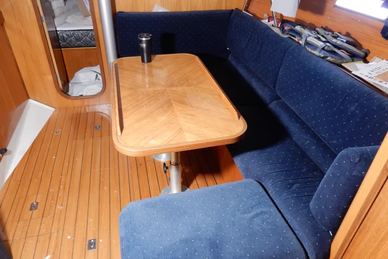 Slide: The Image of Interior of 1991 Beneteau Oceanis 370 sailboat with wooden table and blue seating. - 20
