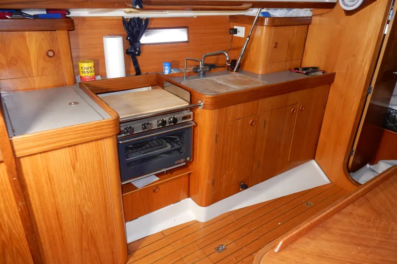 Slide: The Image of Interior of 1991 Beneteau Oceanis 370 yacht kitchen with wood cabinetry and stove. - 21