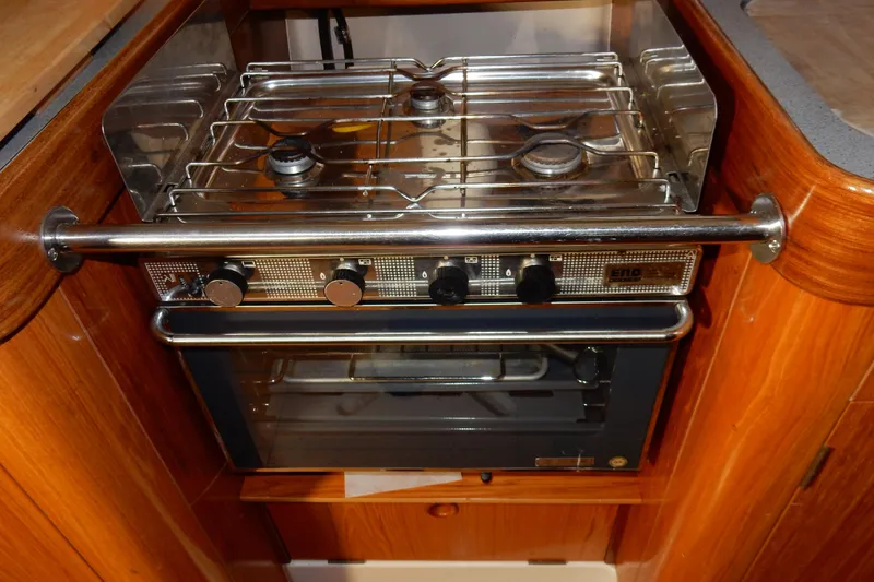 Slide: The Image of Stove and oven in 1991 Beneteau Oceanis 370 yacht kitchen, featuring wooden cabinetry. - 23