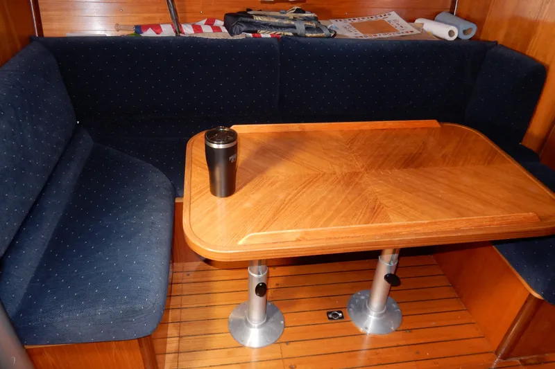 Slide: The Image of Interior of 1991 Beneteau Oceanis 370 with wooden table and blue seating. - 25