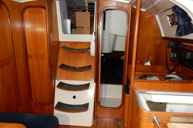 Slide: The Image of Interior of 1991 Beneteau Oceanis 370 sailboat with wooden cabinetry and steps. - 26