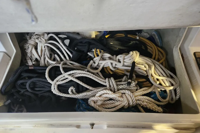 Slide: The Image of Assorted ropes stored in a compartment of a 1991 Beneteau Oceanis 370 sailboat. - 54