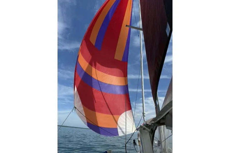 Slide: The Image of Colorful spinnaker sail on 1991 Beneteau Oceanis 370 against blue sky. - 7