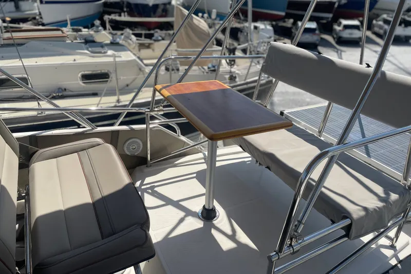 Slide: The Image of 2021 Cutwater C-32 CB boat seating area with table, docked at marina. - 15