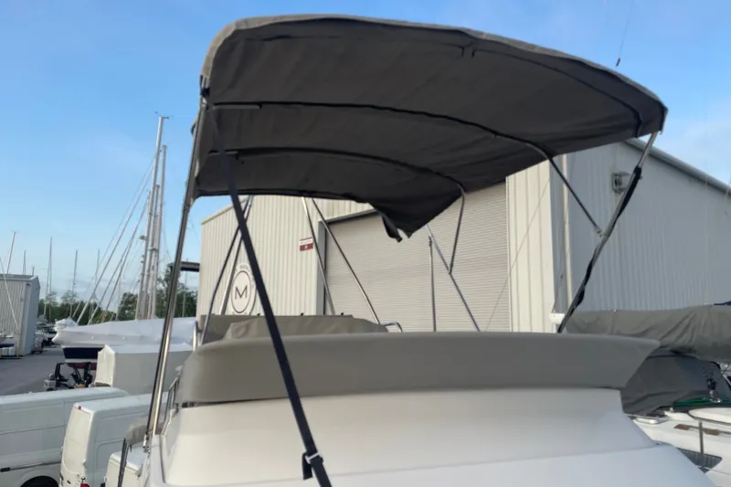Slide: The Image of 2021 Cutwater C-32 CB boat with canopy, docked near storage facility. - 21