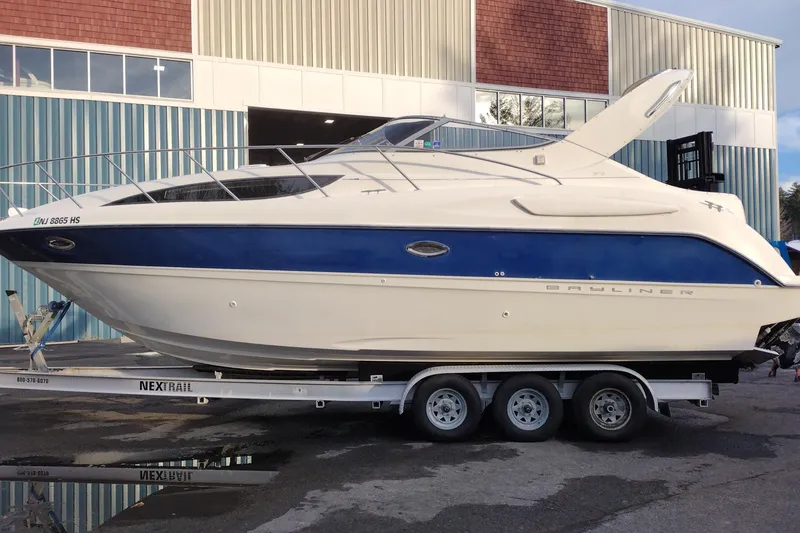 The Image of 2005 Bayliner 305 boat on trailer, parked outside a building. - 1