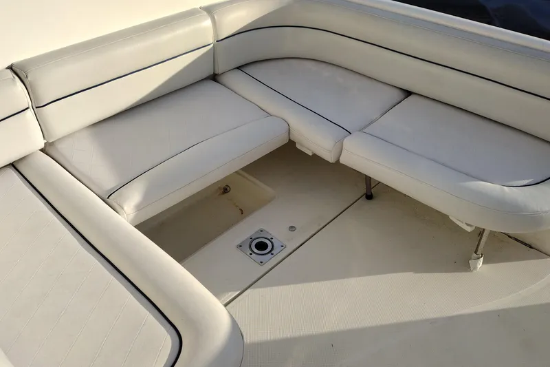 Slide: The Image of 2005 Bayliner 305 boat interior with white cushioned seating and storage compartment. - 11