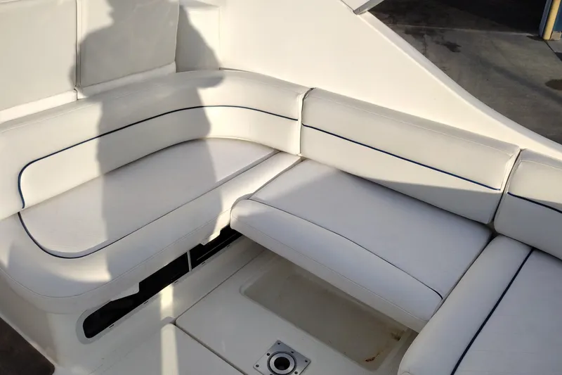 Slide: The Image of 2005 Bayliner 305 boat interior with white cushioned seating. - 12