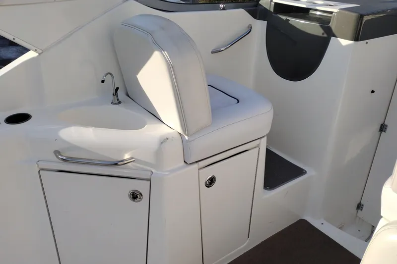 Slide: The Image of 2005 Bayliner 305 boat interior with white seating and compact sink area. - 13