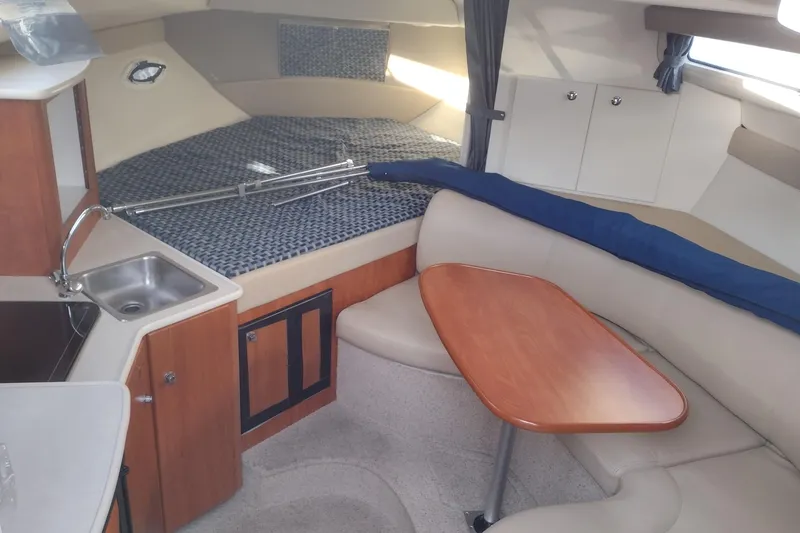 Slide: The Image of Interior of a 2005 Bayliner 305 boat with kitchenette and seating area. - 16