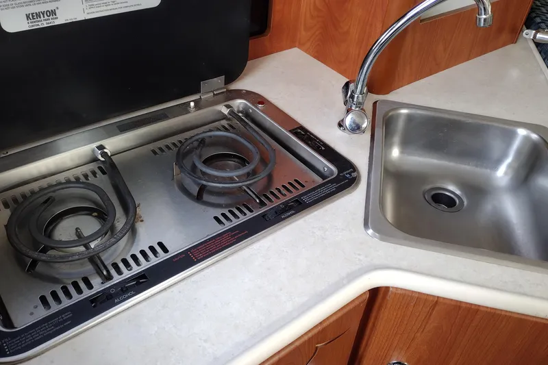 Slide: The Image of 2005 Bayliner 305 boat kitchen with stove and sink. - 21