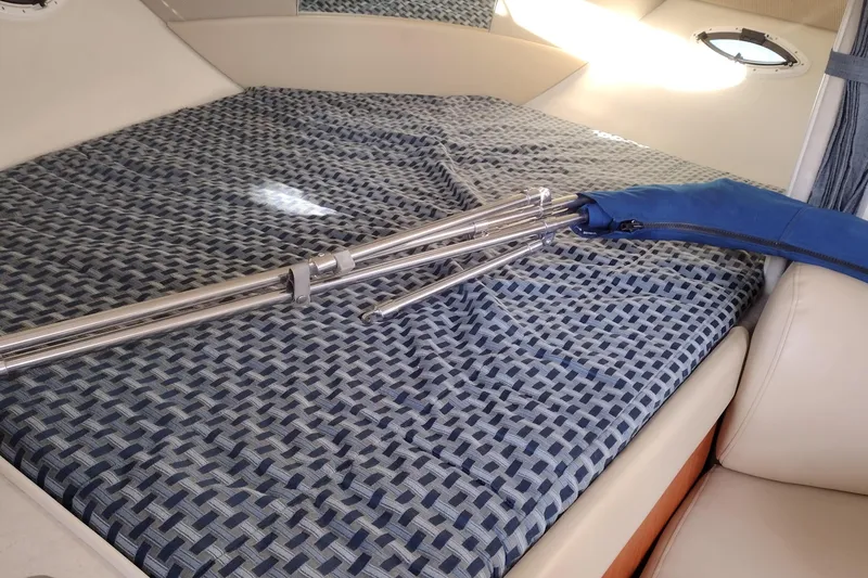 Slide: The Image of Interior of 2005 Bayliner 305 boat with folded metal poles on patterned bed. - 22