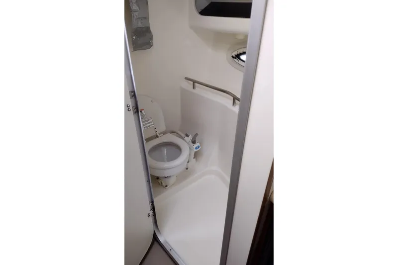 Slide: The Image of Compact bathroom in 2005 Bayliner 305 boat, featuring a toilet and shower area. - 26