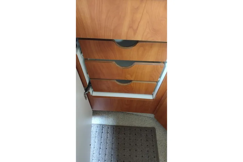 Slide: The Image of Wooden cabinetry inside a 2005 Bayliner 305 boat, featuring three drawers. - 30