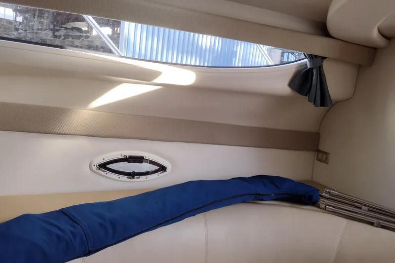 Slide: The Image of Interior of 2005 Bayliner 305 boat with window and blue cover. - 31