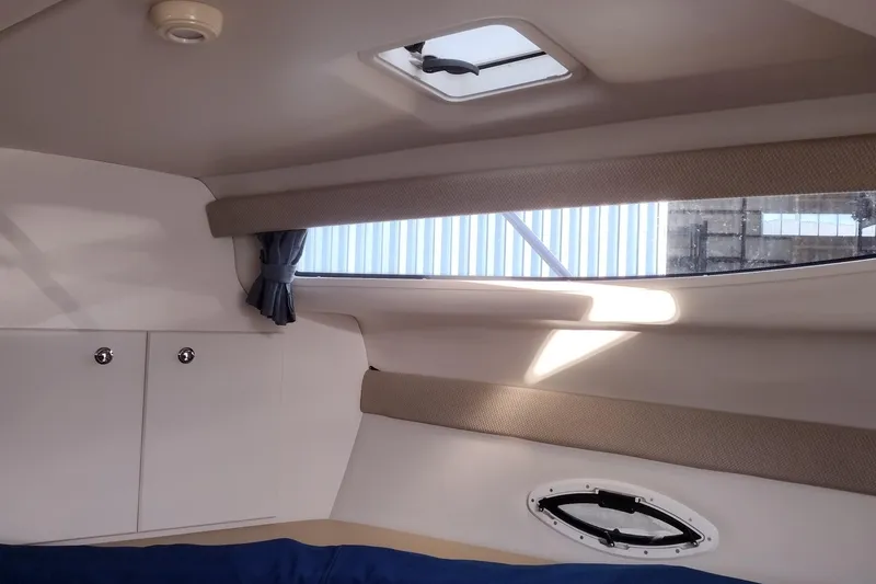 Slide: The Image of Interior cabin of a 2005 Bayliner 305 boat with window and storage. - 32