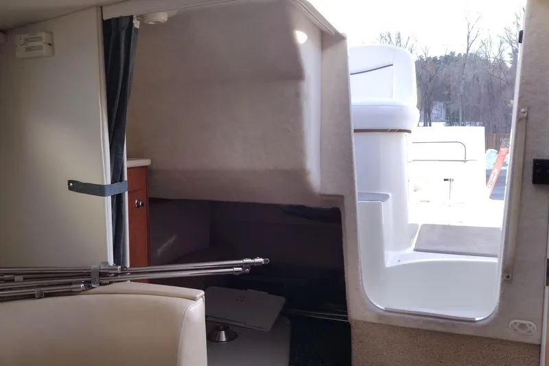 Slide: The Image of Interior view of a 2005 Bayliner 305 boat cabin with seating and access to deck. - 33
