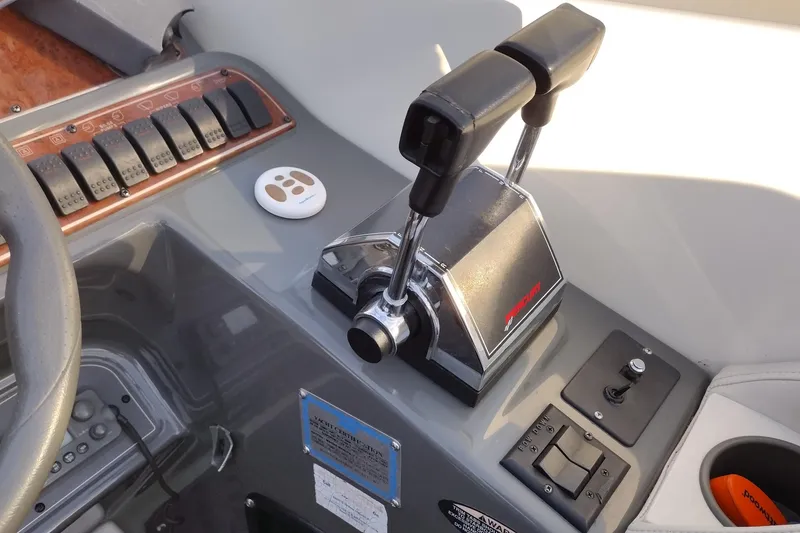 Slide: The Image of 2005 Bayliner 305 boat controls with throttle levers and dashboard switches. - 35