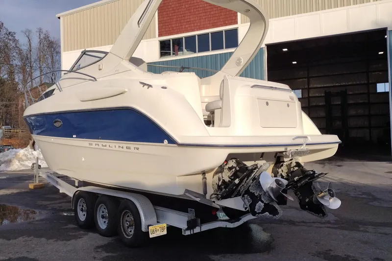 Slide: The Image of 2005 Bayliner 305 boat on trailer, parked outside a warehouse. - 8