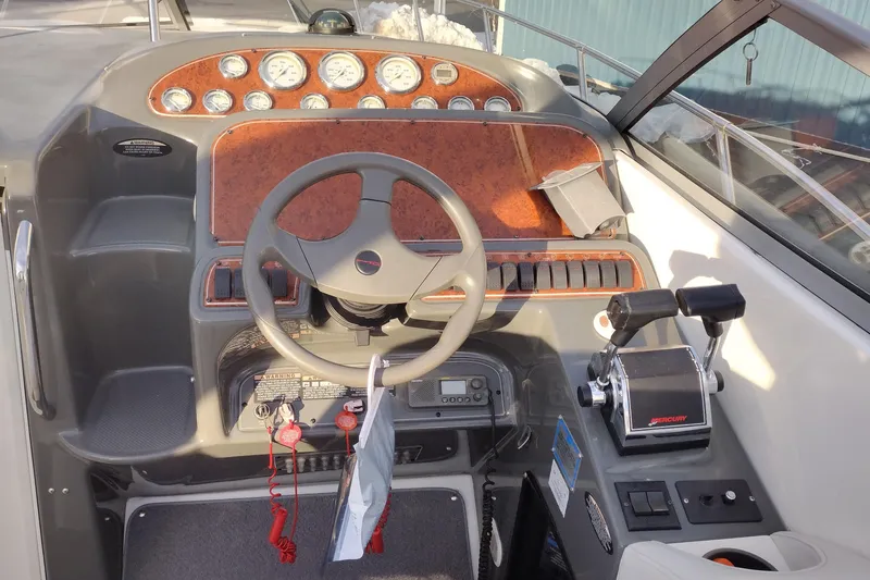 Slide: The Image of 2005 Bayliner 305 boat dashboard with steering wheel and control panel. - 9