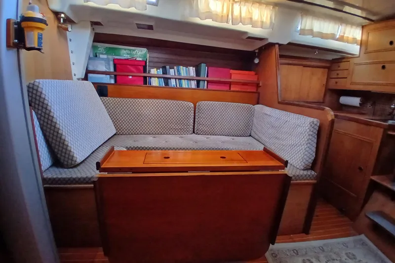 Slide: The Image of Interior of 1983 Wauquiez Hood sailboat with cozy seating and wooden cabinetry. - 10