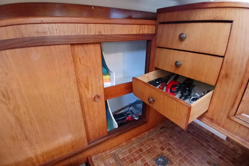 Slide: The Image of Wooden interior of 1983 Wauquiez Hood yacht with open drawer showing tools. - 13