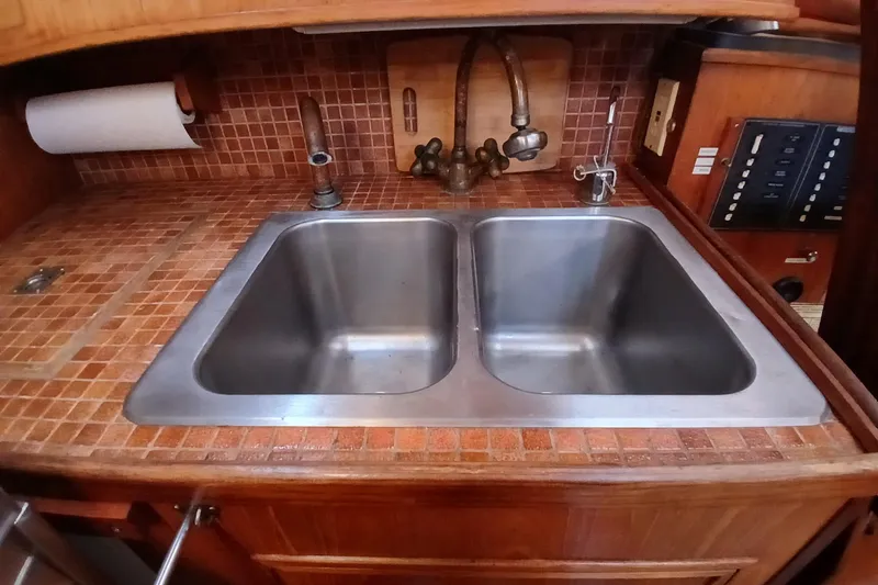 Slide: The Image of 1983 Wauquiez Hood yacht kitchen with double stainless steel sink and wooden cabinetry. - 14