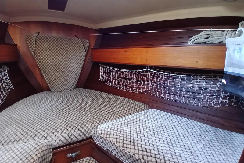 Slide: The Image of Interior cabin of 1983 Wauquiez Hood sailboat with checkered cushions and wooden finish. - 15
