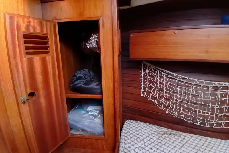 Slide: The Image of 1983 Wauquiez Hood yacht interior with wooden cabinetry and storage netting. - 17