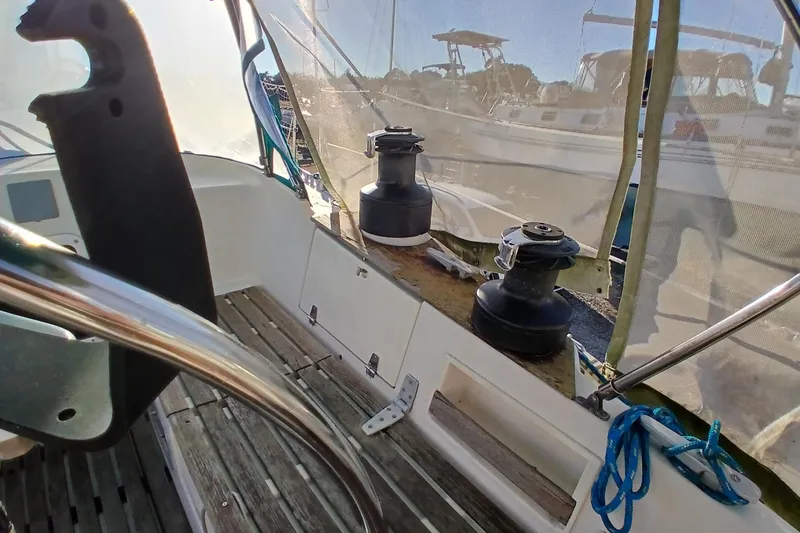Slide: The Image of Cockpit of 1983 Wauquiez Hood sailboat with winches and ropes, docked in marina. - 52