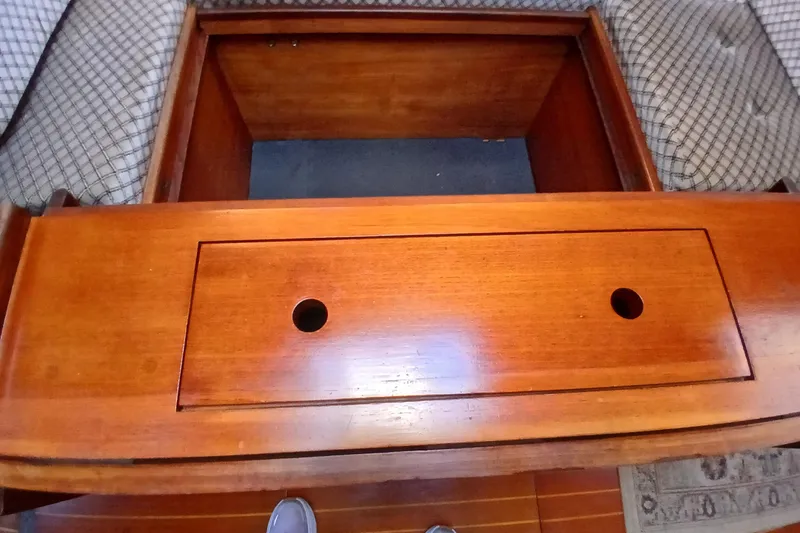 Slide: The Image of Interior of 1983 Wauquiez Hood sailboat with wooden storage compartment and cushioned seating. - 7