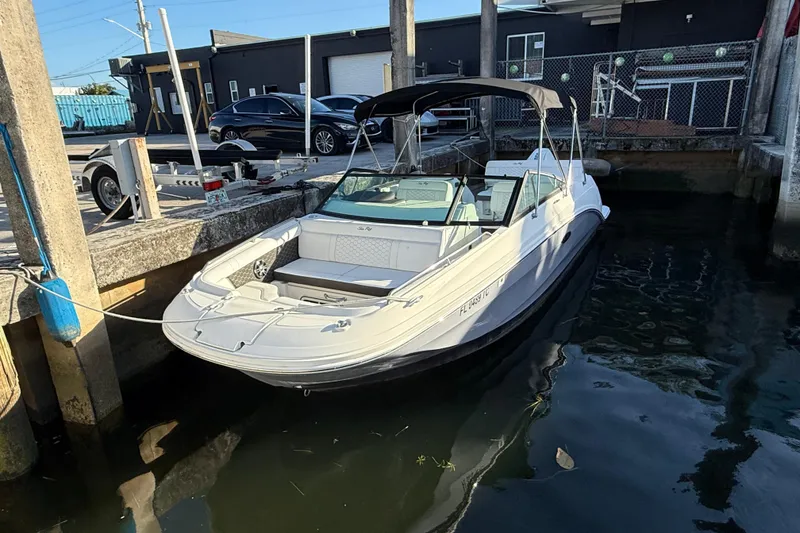 The Image of 2022 Sea Ray SDX 250 boat docked at a marina, featuring sleek design and canopy. - 1