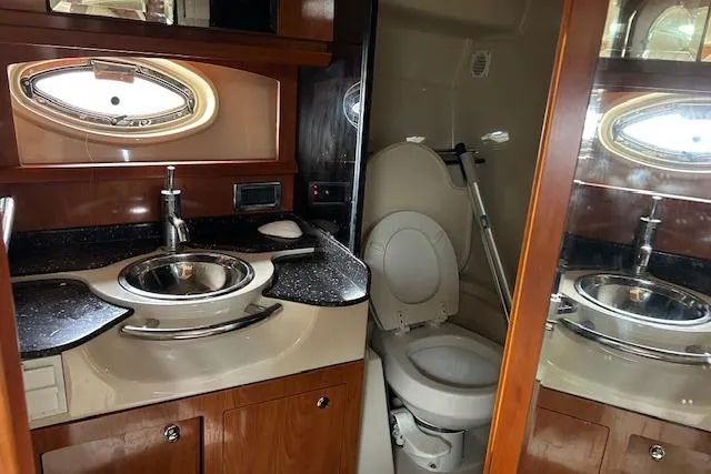Slide: The Image of 2007 Four Winns 358 Vista yacht bathroom with sink, toilet, and porthole window. - 10