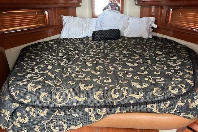 Slide: The Image of 2007 Four Winns 358 Vista cabin interior with patterned bedding and wooden accents. - 5