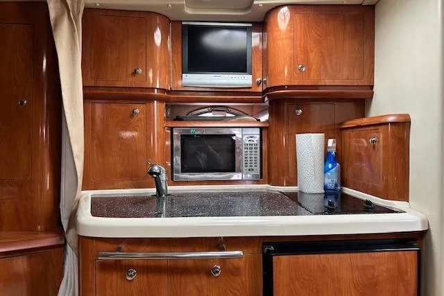 Slide: The Image of 2007 Four Winns 358 Vista yacht kitchen with wood cabinets, microwave, and TV. - 6