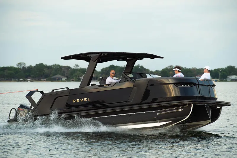 Slide: The Image of Manufacturer Provided Image: 2026 Revel RS25L luxury boat cruising on a serene lake with passengers onboard. - 7